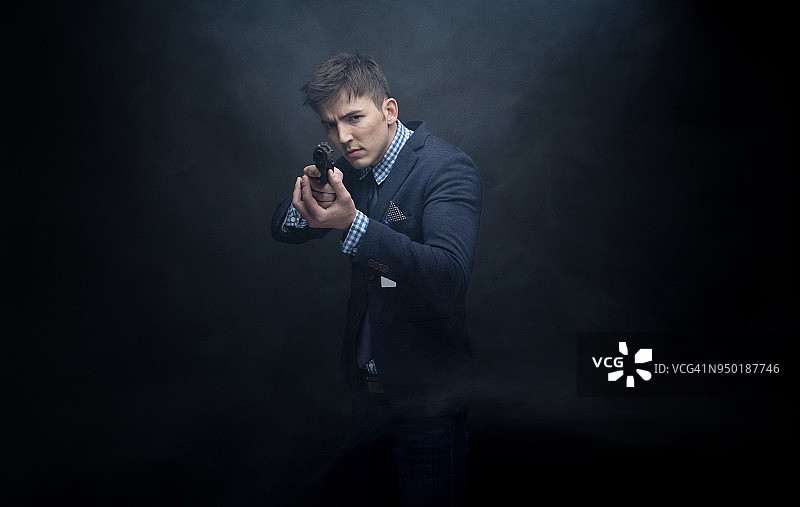 衣着讲究的商人用枪瞄准图片素材