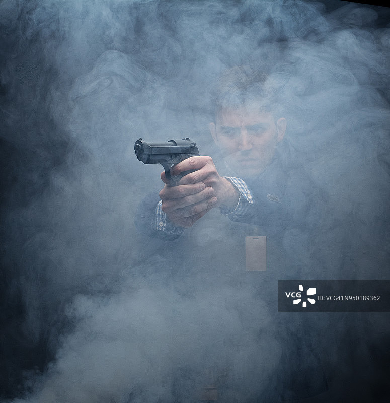 衣着讲究的商人用枪瞄准图片素材