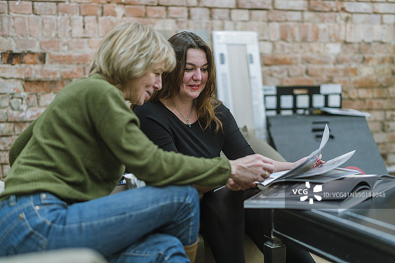两位年龄分别为30岁和50岁的女商人在现代自由式办公室讨论项目图片素材