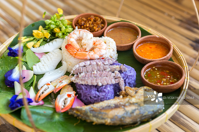 精美的泰国菜：搭配海鲜和各种香辣酱的彩色糯米饭图片素材