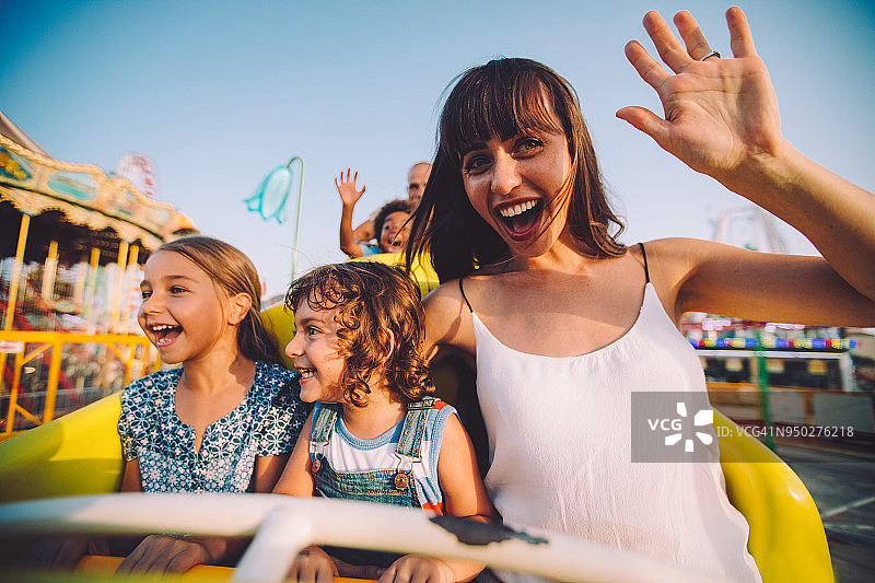 孩子们和母亲在过山车上玩耍图片素材