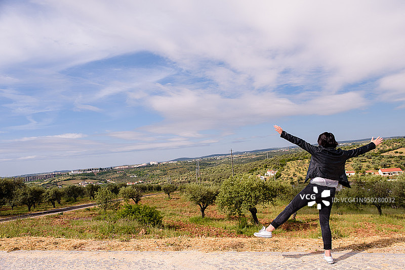 年轻女人张开双臂眺望葡萄牙阿尔卡科瓦小镇景色图片素材