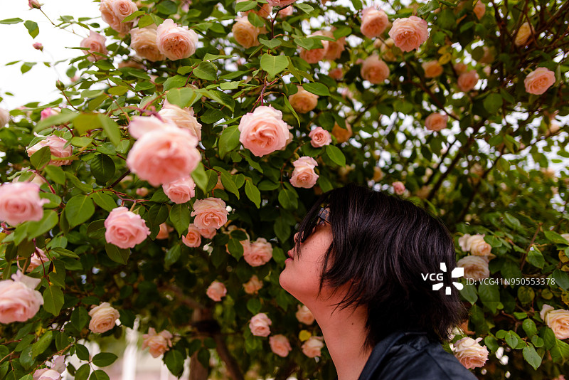 年轻女子嗅花特写图片素材