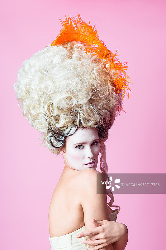 戴假发巴洛克女人粉色背景肖像图片素材