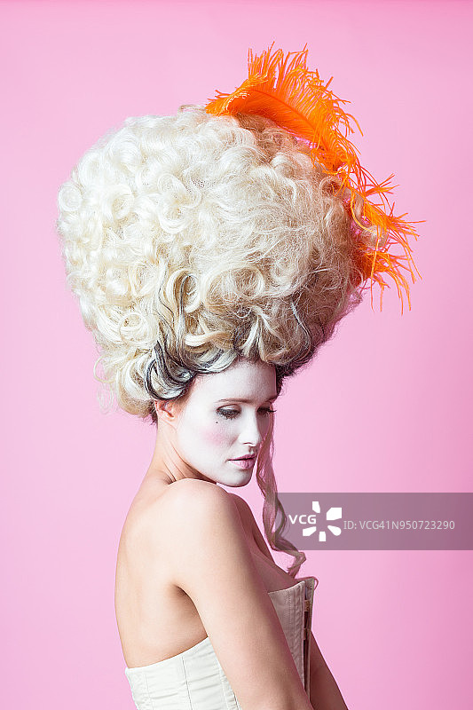 戴假发巴洛克女人粉色背景肖像图片素材