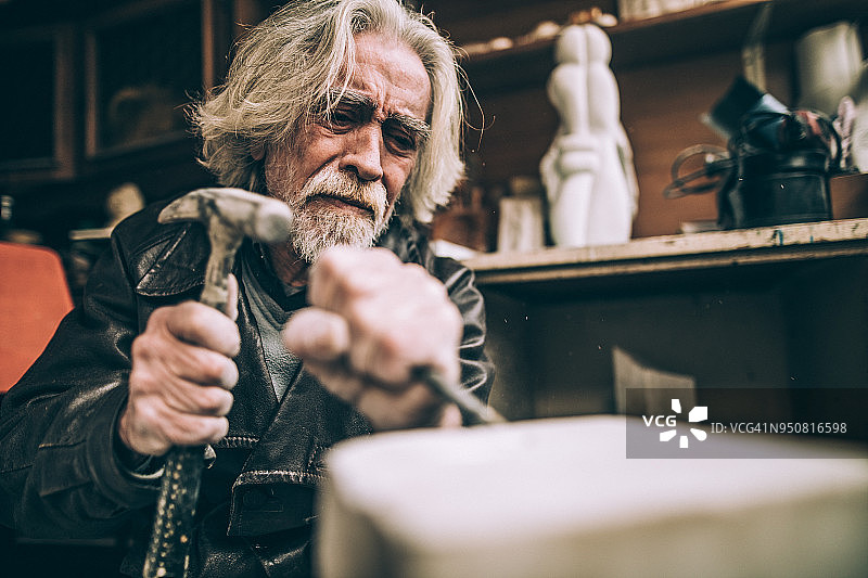 在室内工作的年长石匠图片素材