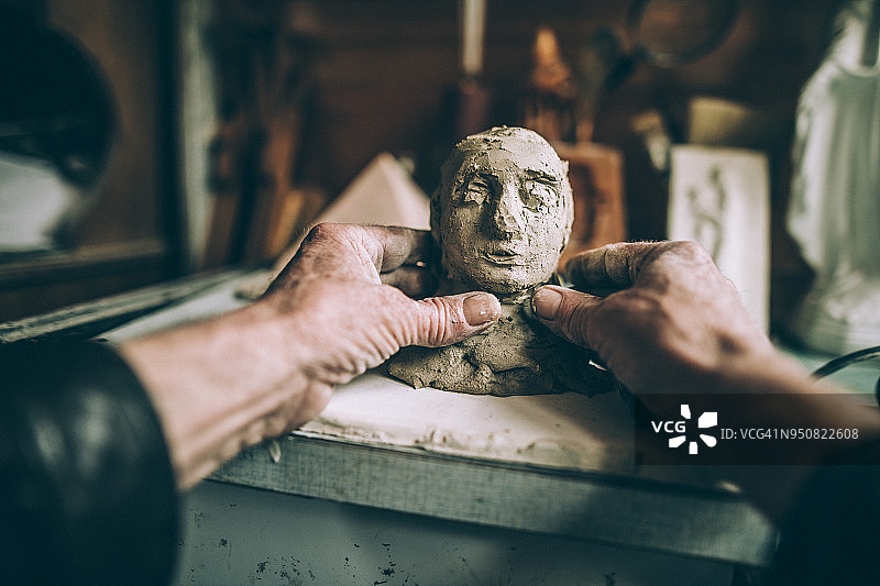 年长的男人用手制作粘土雕像图片素材