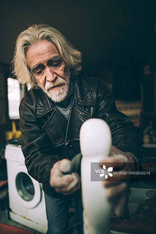 年长的男人在车库里做艺术品图片素材