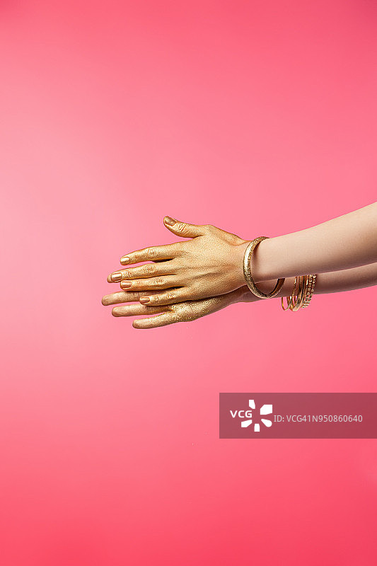 涂有金色油漆的女性手部局部特写图片素材