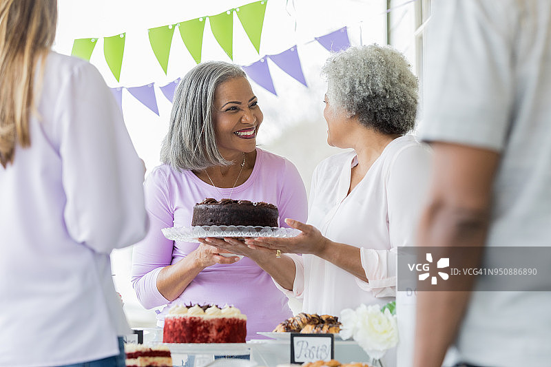 妇女在义卖会上捐赠巧克力蛋糕图片素材