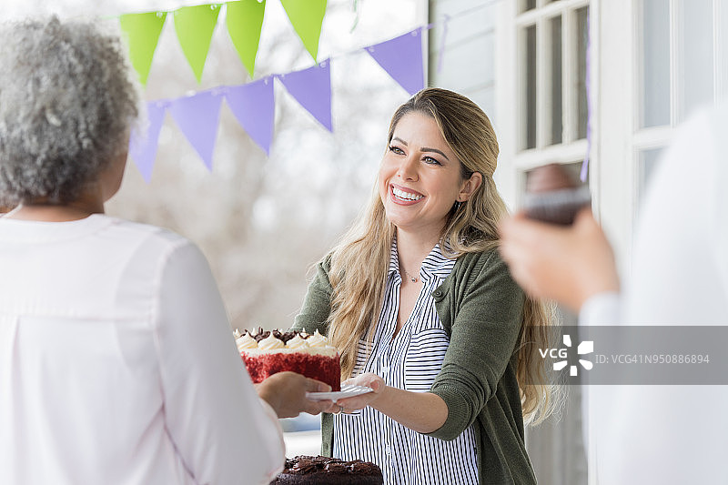 志愿者在慈善义卖会上收到捐赠的蛋糕图片素材