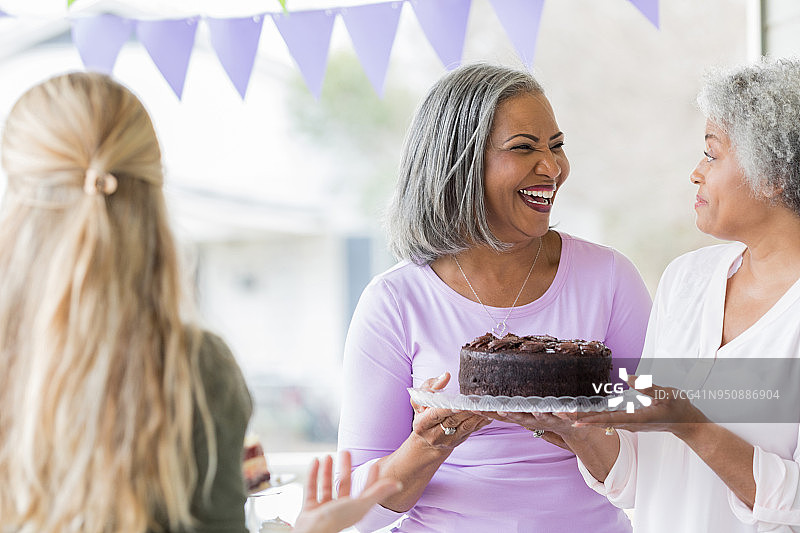 老年妇女在义卖会上购买蛋糕图片素材