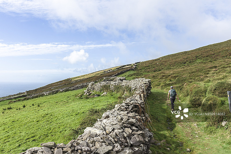 在爱尔兰丁格尔斯利亚角徒步的女人图片素材