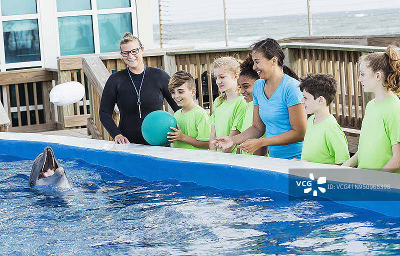 海洋公园里，孩子们与海豚和驯养员图片素材