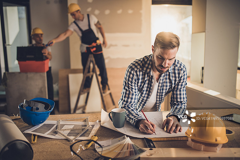 男建筑师在建筑工地绘制房屋平面图图片素材