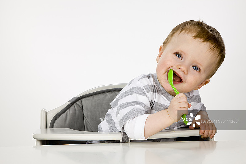 拿着勺子的男婴图片素材