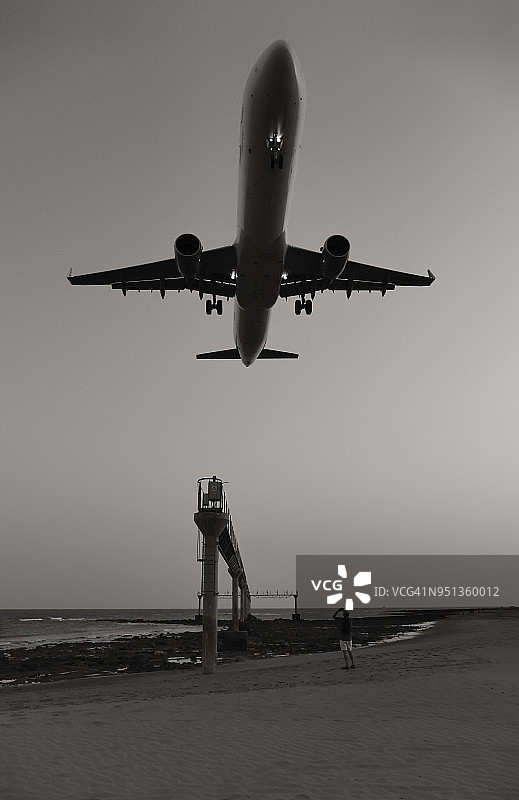 飞机在兰萨罗特岛马塔戈达海滩上空着陆，西班牙加那利群岛图片素材