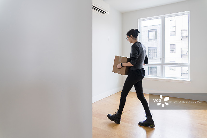 少女将箱子搬进空荡荡的新公寓图片素材