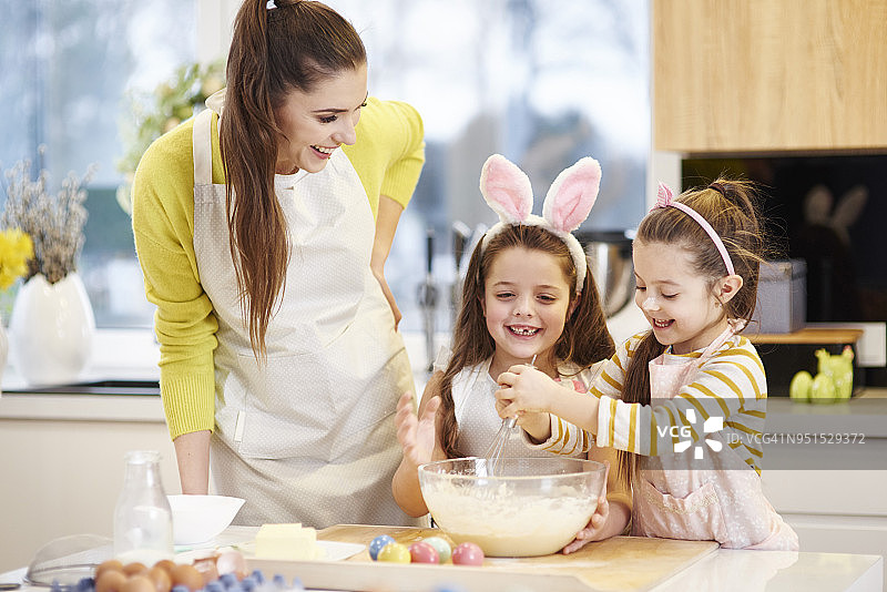 快乐的母女一起在厨房烤复活节饼干图片素材