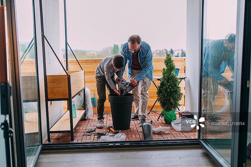 父子在阳台上制作花园图片素材
