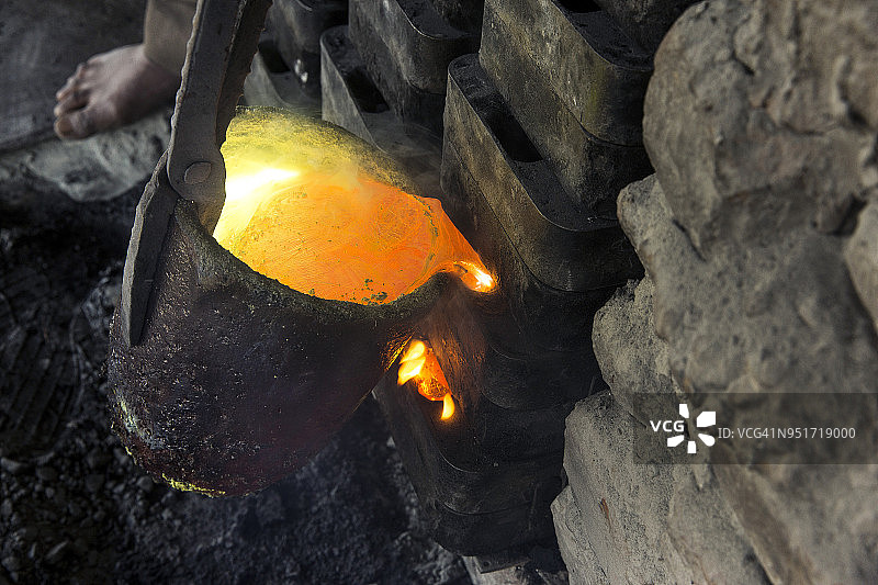 工人将熔融金属合金倒入模具中图片素材