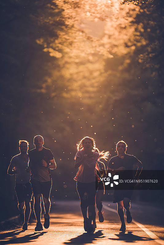 一群坚定的运动员在日落时参加马拉松比赛图片素材