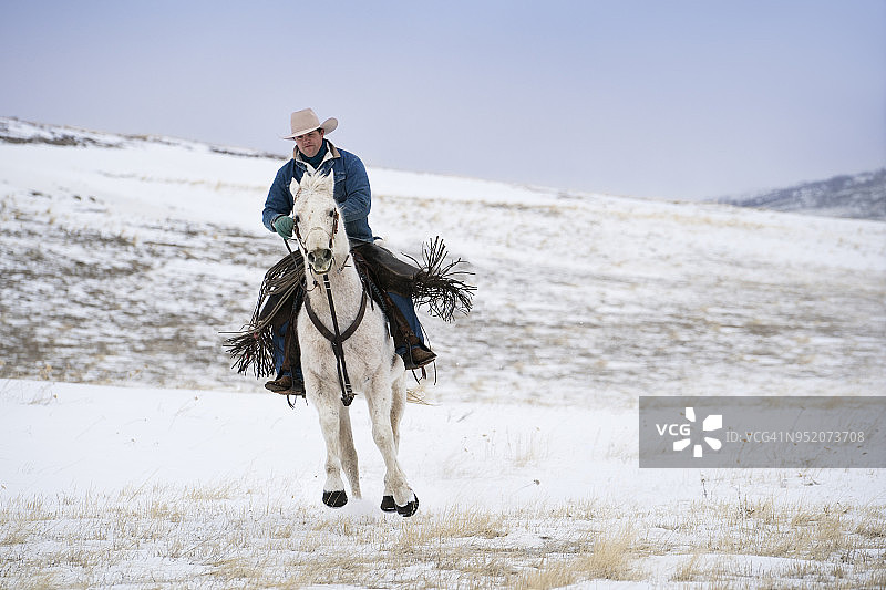 在雪山上飞驰的牛仔图片素材