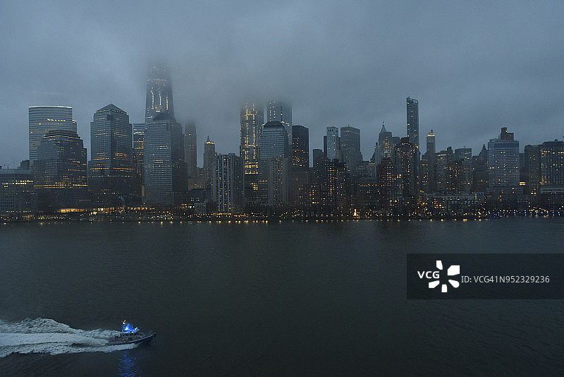 多云的曼哈顿下城天际线和纽约市警察船图片素材