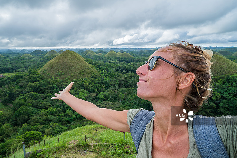 在菲律宾薄荷岛巧克力山张开双臂旅行的女人图片素材