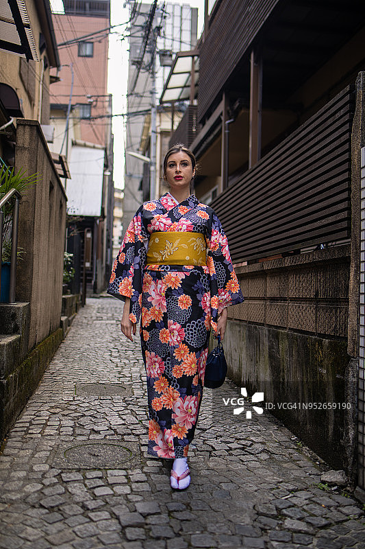 穿着和服走在狭窄街道上的英国女人图片素材