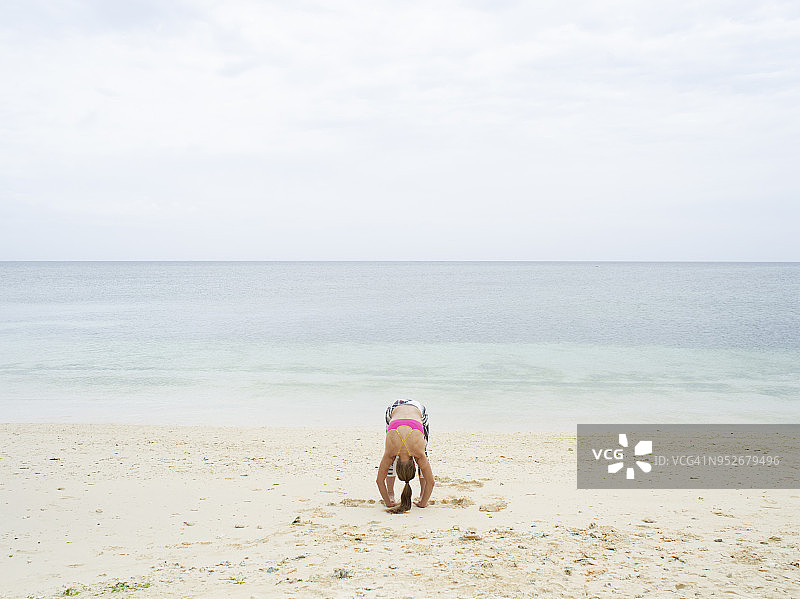 一个在海滩上练瑜伽的女人图片素材