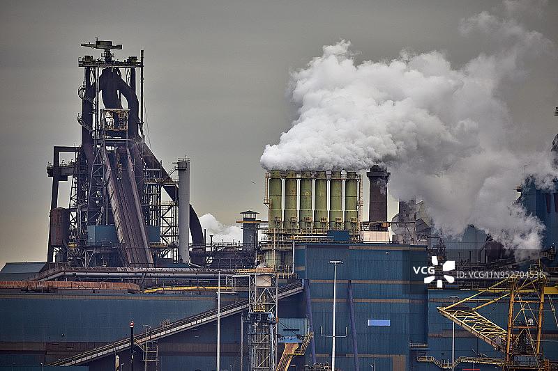 重工业：阴沉天空下，烟囱排放大量浓烟的工厂图片素材