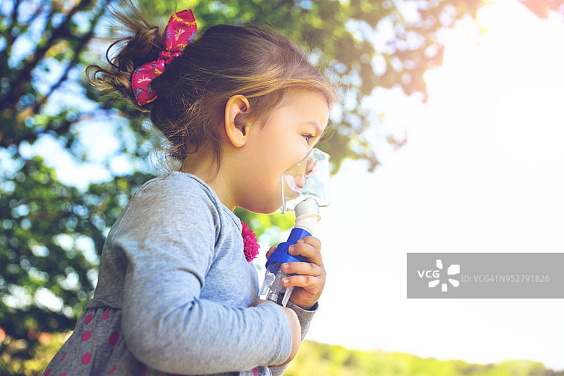 在公园使用哮喘吸入器的女孩图片素材