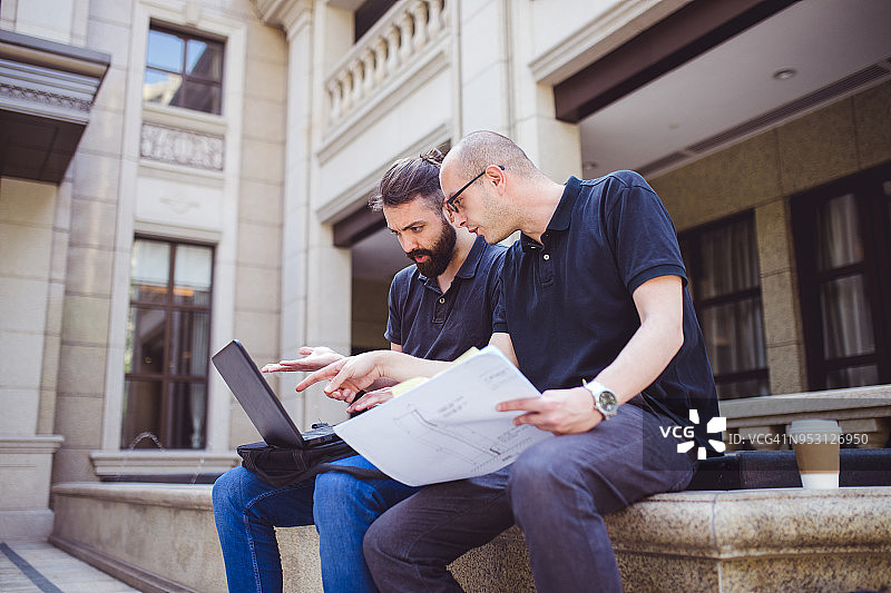 敬业的年轻建筑师在公共建筑外工作图片素材