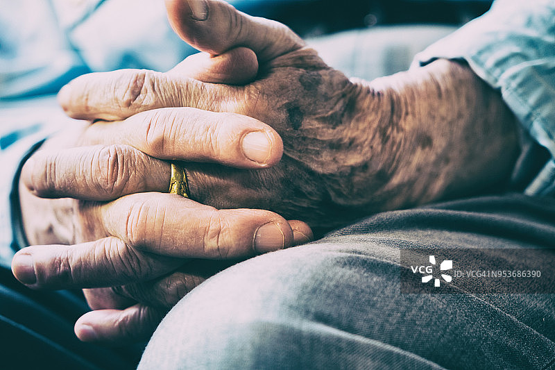 坐在椅子上交叉双臂的老年男人图片素材