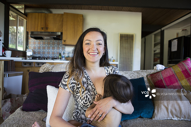 年轻的母亲给女儿喂母乳图片素材