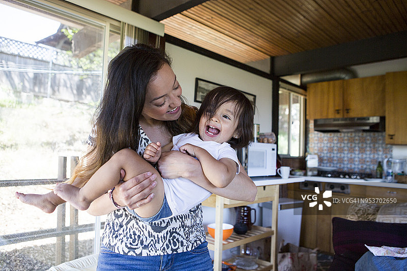年轻妈妈和女儿室内玩耍开心地笑图片素材