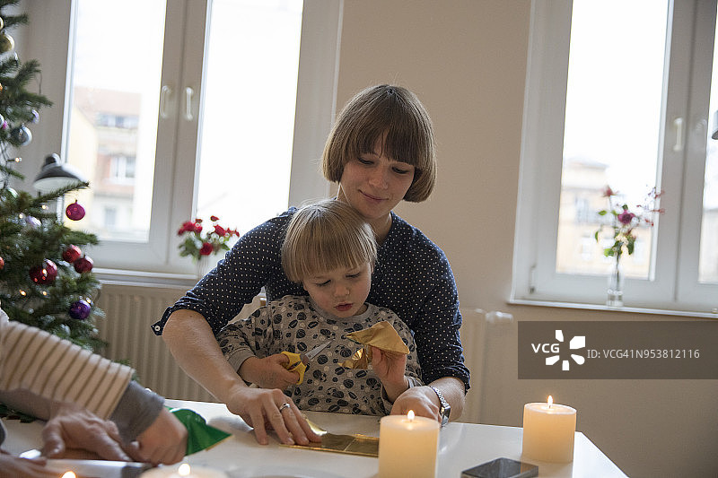 客厅里，母亲和幼儿男孩在桌旁做手工图片素材
