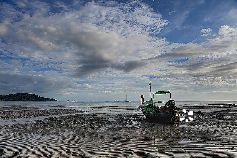 退潮时海滩上的长尾船图片素材