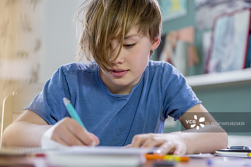 正在做作业的10岁金发小学生图片素材