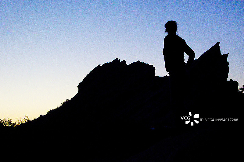 夕阳下瓦斯奎巨岩的女人剪影图片素材