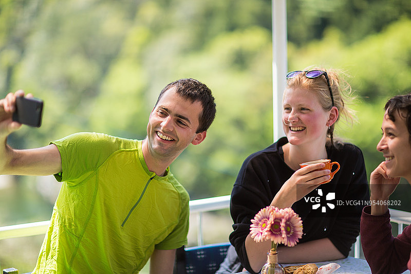 朋友们在露台上吃早餐时自拍图片素材
