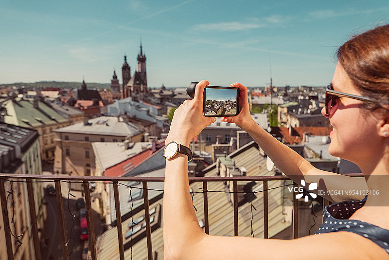女游客在欧洲旅行并用智能手机拍照图片素材