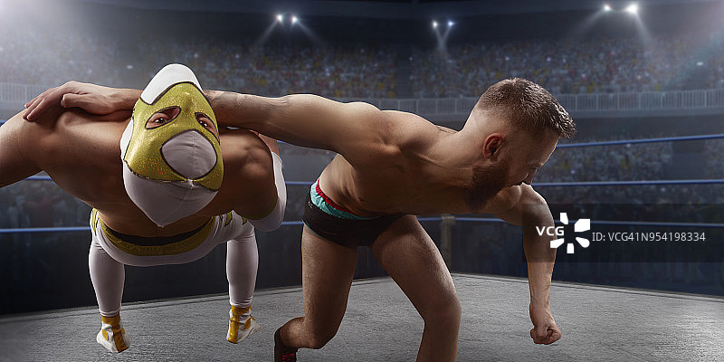 摔跤表演：两位摔跤手在擂台上穿着鲜艳的运动服和面罩搏斗图片素材