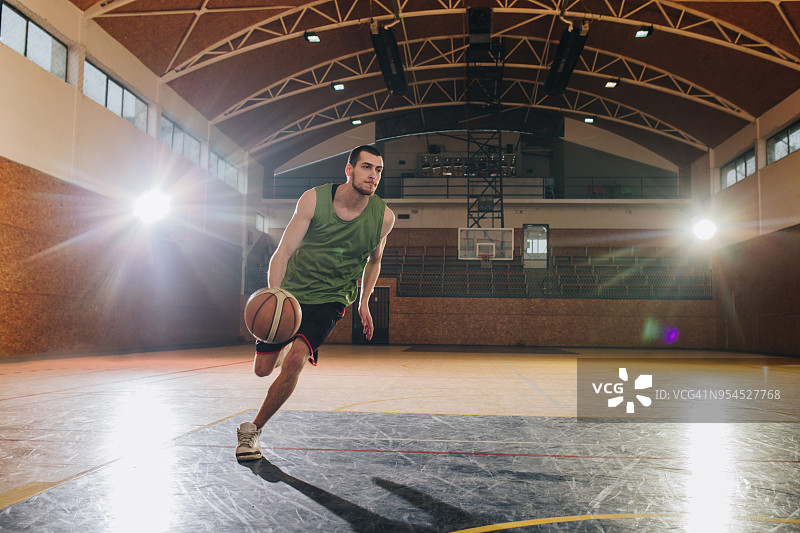 在篮球场上运球的自信篮球运动员图片素材