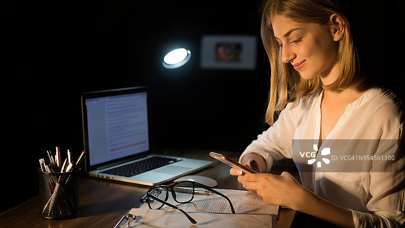 在办公桌前使用手机的女商人图片素材