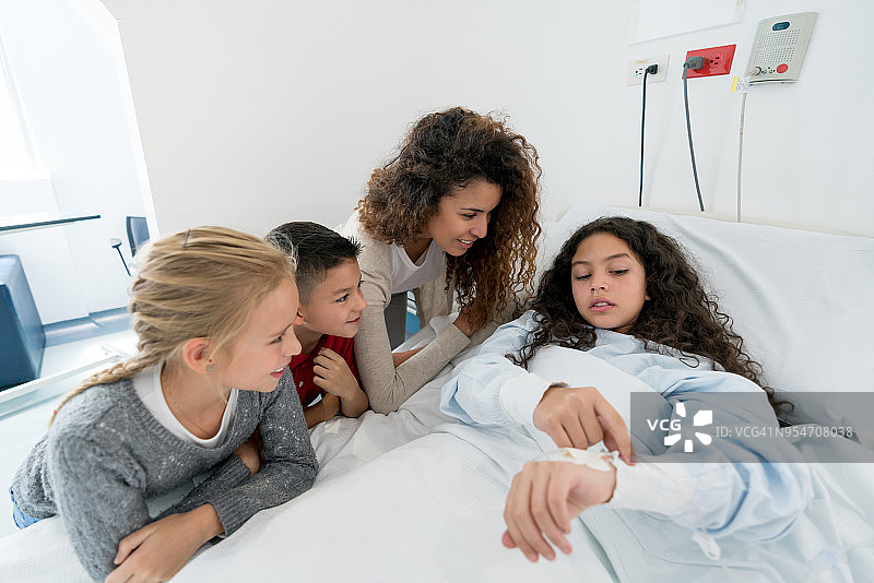 妈妈和朋友在医院探望生病的小女孩图片素材