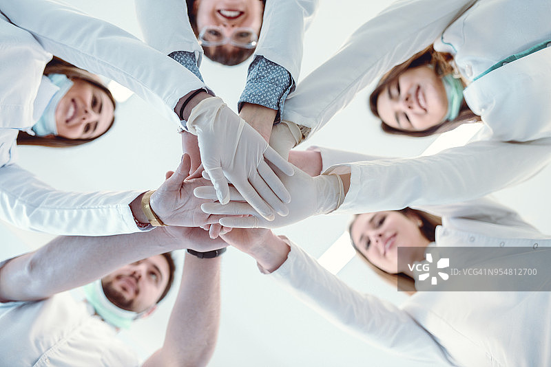 多民族医疗团队手叠手庆祝成功图片素材