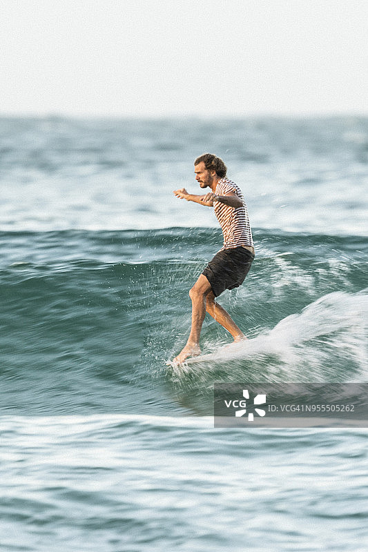 米切尔·瑟曼在努沙国家公园茶树湾的长板上冲浪图片素材