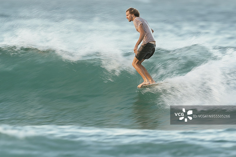 米切尔·瑟曼在努沙国家公园茶树湾的长板上冲浪图片素材